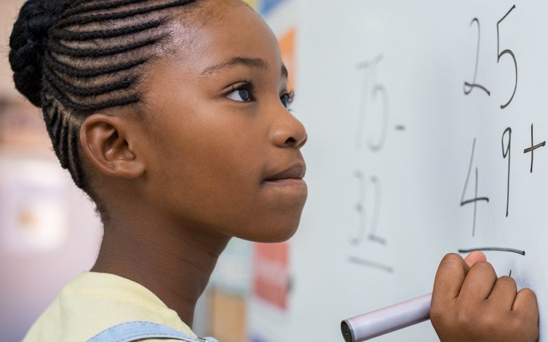 girl writing on board